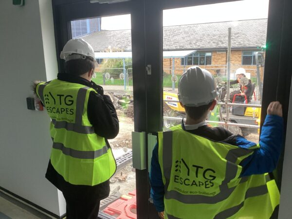 Students looking out of the window of a net-zero modular classroom block in construction