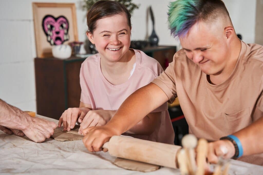 Two children using rolling pins within a special needs (SEND) classroom